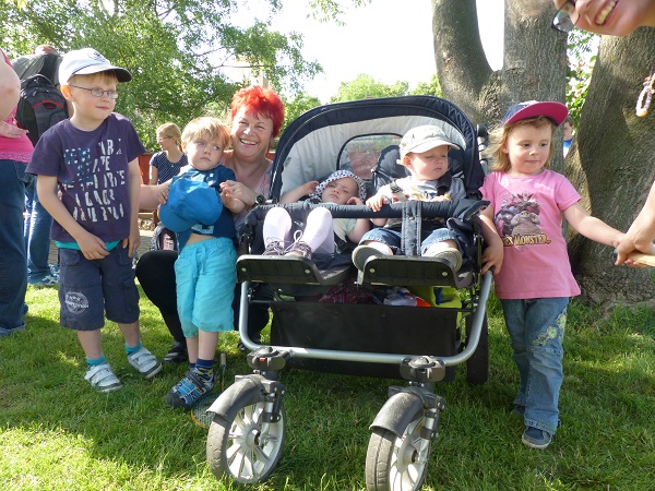 Foto von Kindern und zwei Babies in einem Kinderwagen.